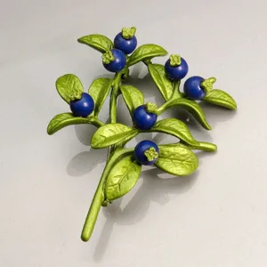Vue détaillée d'une broche myrtille avec feuilles en émail vert et fruits bleus