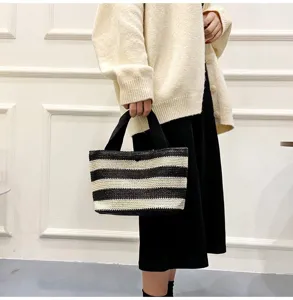 Vue détaillée d'un sac à main en paille tressée à rayures noires et blanches chic