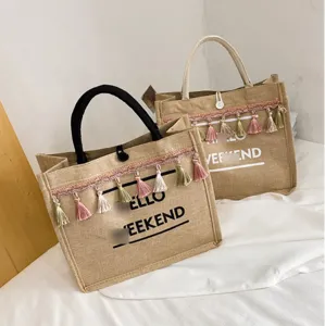 Large capacity minimalist jute tote bags with tassel fringe and 'Hello Weekend' print on white surface
