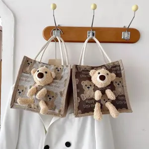 Detailed macro shot of linen teddy bear handbags in both grey and brown color options