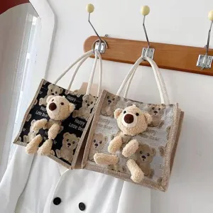 Close-up of black and beige linen tote bags featuring cute 3D plush teddy bear designs