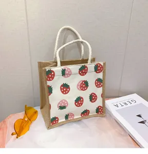 Detaillierte Ansicht der Jute-Canvas-Handtasche mit süßem Erdbeermuster und Seilgriff