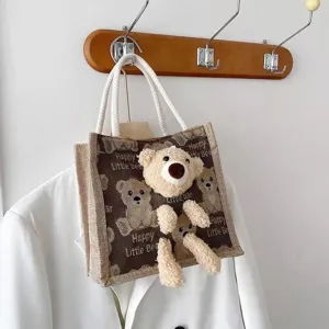 Detail of a linen bento tote bag featuring a 3D plush teddy bear and bear patterns.