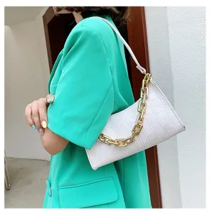 Detalle del bolso de hombro blanco con estampado de cocodrilo y una gruesa cadena dorada