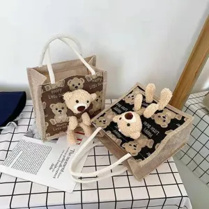 Detailed view of a fashionable linen handbag with a 3D plush teddy bear and print