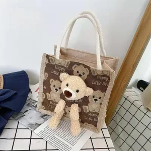 Detailed view of a trendy jute tote bag with a 3D plush teddy bear and cute bear patterns