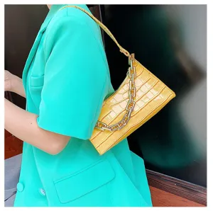 Bolso de hombro amarillo con patrón de cocodrilo y detalle de cadena dorada en el asa