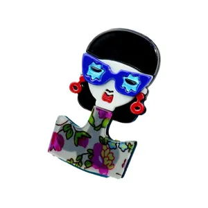 Artistic acrylic girl brooch featuring blue sunglasses and a colorful floral dress design.