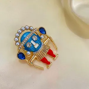 Vue détaillée d'une broche chef tribal exotique avec visage bleu et perles