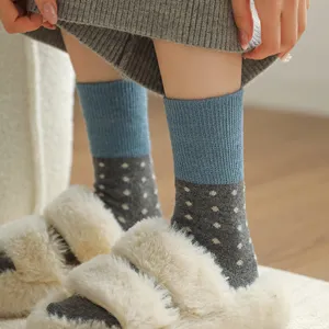 Cozy women's mid-calf wool socks with blue and grey color-blocking and white polka dots.