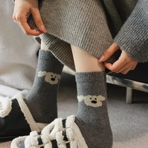 Close-up detail of cozy grey knit socks featuring a cute puppy pattern for winter.