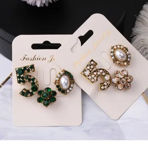 Detail of vintage-style brooch sets including number 5, pearl, and flower designs.
