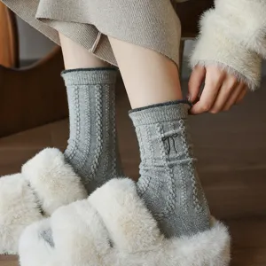 Detailed view of cozy grey knitted wool socks featuring delicate bow embroidery for women.