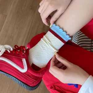 Gros plan sur chaussettes blanches en coton pour femmes avec bordure bleue à volants