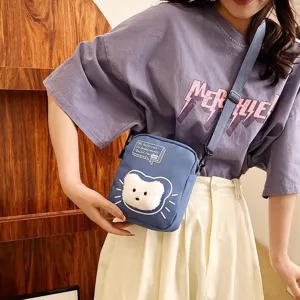 Vista detallada de un bolso bandolera de nailon con gato azul sobre una joven modelo