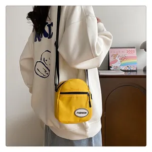 Vista detallada de un mini bolso bandolera de nailon amarillo en un ambiente interior acogedor
