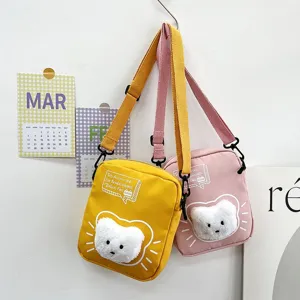 Vista detallada de dos lindos bolsos bandolera de nailon en amarillo y rosa con gato