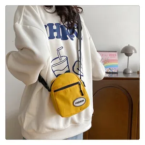 Primer plano de un pequeño bolso bandolera de nailon amarillo de estilo informal