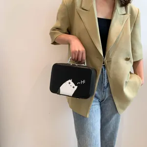 Gros plan d'une trousse à maquillage élégante avec imprimé chat et poignée en métal