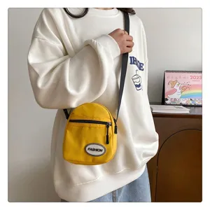 Bolso bandolera pequeño de nailon amarillo para mujer en un conjunto casual diario.