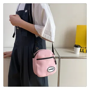 Pequeño bolso bandolera de nailon rosa para mujer en un entorno de estilo de vida.