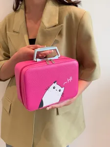 Étui à maquillage rose élégant avec imprimé chat de dessin animé, tenu par une personne