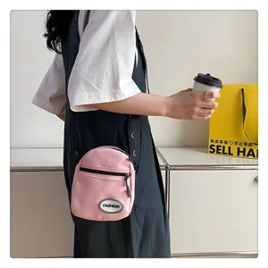 Primer plano de un bolso bandolera de nailon rosa usado en un ambiente casual