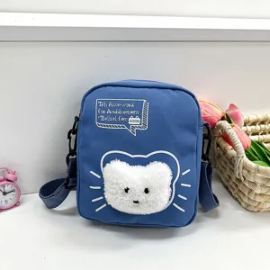 Primer plano de bolso bandolera de nailon azul con cara de gato peluda para niñas