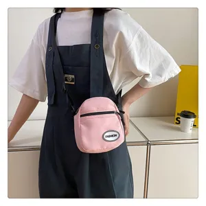 Bolso bandolera de nailon rosa con peto vaquero en un entorno de estilo minimalista