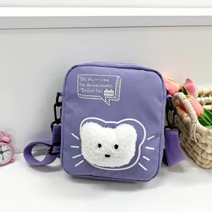 Vista detallada de un bolso bandolera de nailon morado con un lindo parche de gato blanco suave