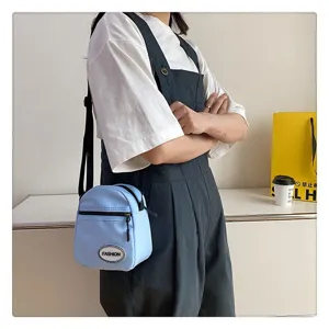 Bolso bandolera de nailon azul claro llevado por una modelo en toma de estilo de vida.