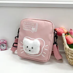 Detalle de bandolera de nailon rosa con cara de gato de peluche y gráficos blancos