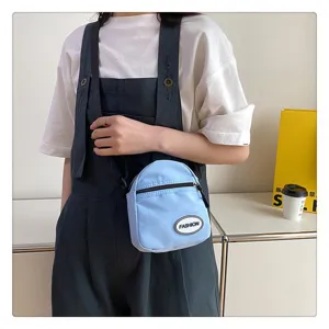 Mini bolso bandolera de nailon azul claro para mujer, usado en un estilo casual diario.