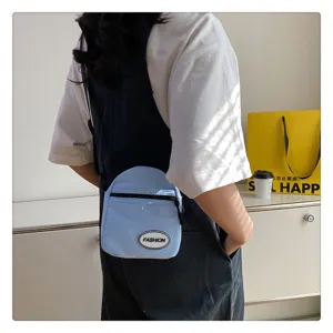 Primer plano de un mini bolso bandolera ligero de nailon azul llevado por una modelo de moda