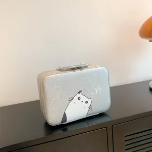 Boîte de maquillage argentée avec imprimé chat mignon et poignée supérieure.