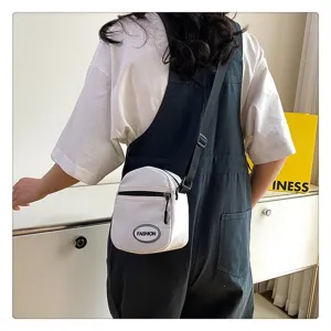 Vista posterior de un bolso bandolera de nailon blanco minimalista con un mono negro