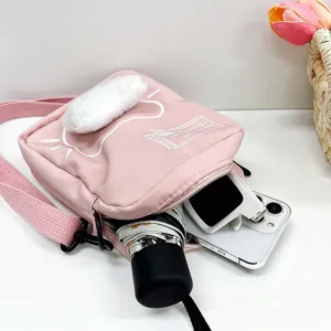 Detalle del bolso bandolera de gato rosa en nailon mostrando su capacidad interior