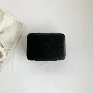 Boîte à maquillage élégante en cuir texturé noir présentée dans une vue de dessus épurée.