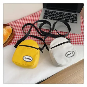 Detalle de bolsos bandolera de nylon amarillo y blanco en un entorno de estilo de vida.