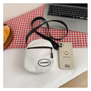 Vista superior de un pequeño bolso bandolera de nailon blanco para el móvil