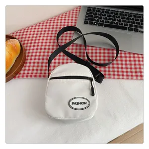 Vista detallada de un pequeño bolso bandolera de nailon blanco estilo minimalista