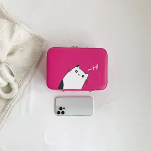 Zoom sur une trousse de maquillage rose avec imprimé chat et fermeture éclair argentée