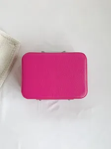 Vue détaillée de la mallette de maquillage en cuir rose fuchsia sur fond blanc