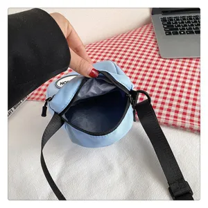 Vista detallada del interior de un pequeño bolso bandolera de nailon azul claro para mujer