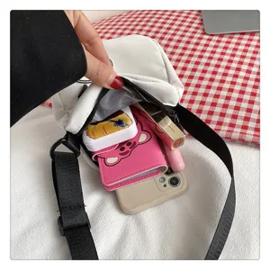 Vista detallada del bolso bandolera de nailon blanco que muestra la capacidad interna y accesorios