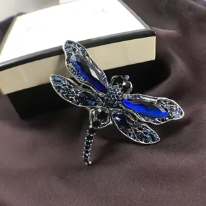 Detailed view of a vintage dragonfly brooch with brilliant blue crystals and silver plating