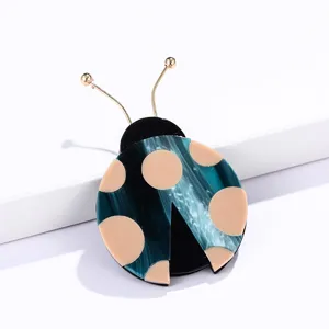 Lindo broche de mariquita de acetato con textura de mármol