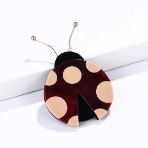 Bonito broche de mariquita minimalista con cuerpo granate y lunares color beige