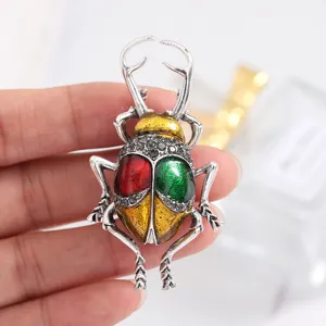 Detailed view of a vintage beetle brooch featuring colorful enamel and shiny crystal embellishments