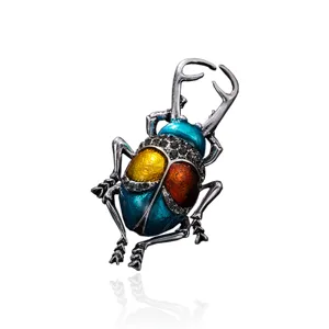 Detail view of a vintage colorful beetle brooch with enamel wings and black rhinestones.